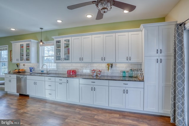 kitchen with a ceiling fan, a sink, pendant lighting, dishwasher, and backsplash