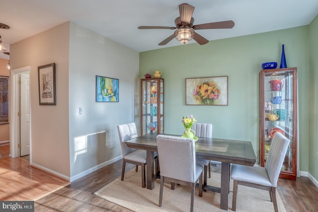 dining room featuring a ceiling fan, wood finished floors, and baseboards