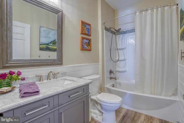 bathroom with vanity, wood finished floors, toilet, and shower / bathtub combination with curtain