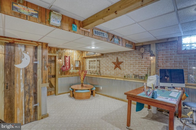 office space with a paneled ceiling and wooden walls