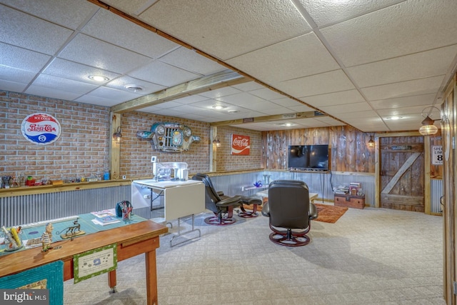 game room featuring brick wall and a drop ceiling