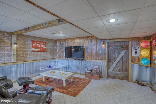 carpeted living area featuring wooden walls, recessed lighting, a paneled ceiling, and visible vents