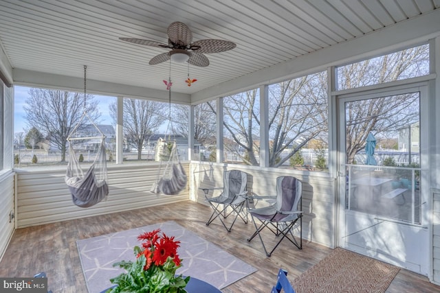 unfurnished sunroom featuring a ceiling fan