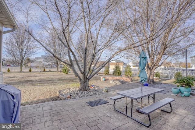 view of patio featuring a grill and fence