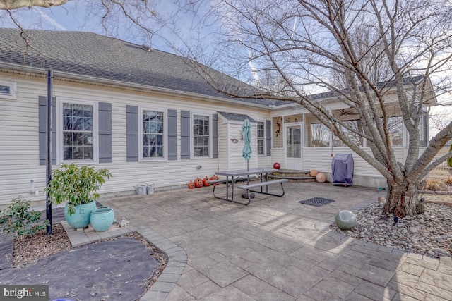 rear view of house with a patio area and a shingled roof