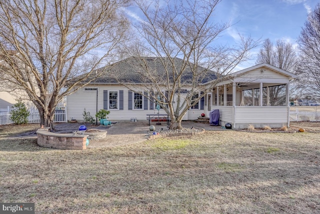 rear view of property featuring entry steps, fence, a yard, a sunroom, and a patio area