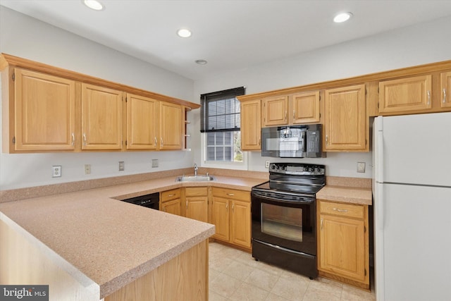 kitchen featuring light countertops, recessed lighting, a peninsula, black appliances, and a sink