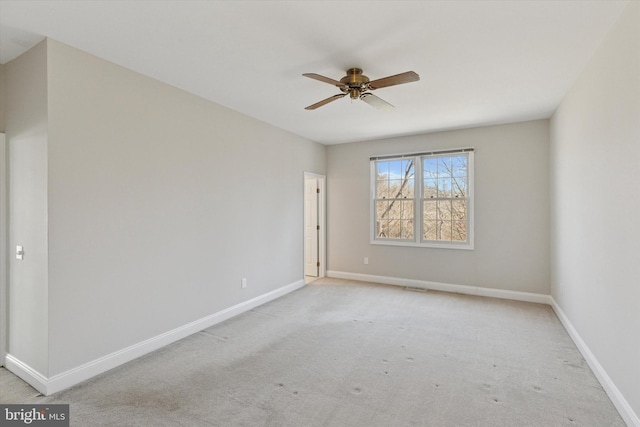 spare room with light carpet, baseboards, and ceiling fan