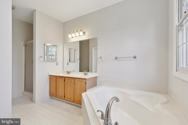 full bath featuring a garden tub, double vanity, a stall shower, and tile patterned floors