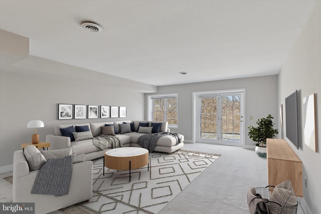 living room featuring baseboards, visible vents, and carpet floors