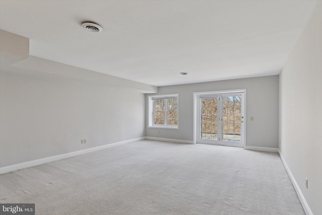 carpeted spare room with baseboards and visible vents