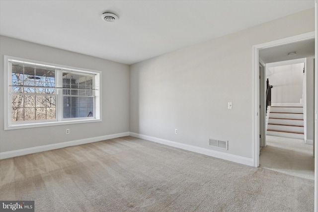 empty room with visible vents, baseboards, and carpet floors