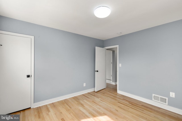 empty room with visible vents, baseboards, and wood finished floors