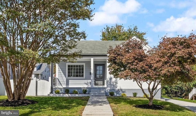 view of front of property with a porch, a front yard, and fence