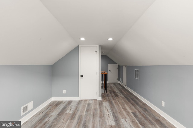 bonus room with visible vents, baseboards, lofted ceiling, and wood finished floors