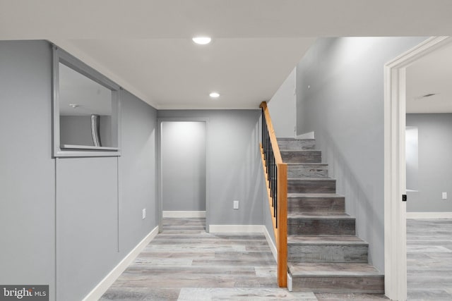 staircase featuring recessed lighting, baseboards, and wood finished floors