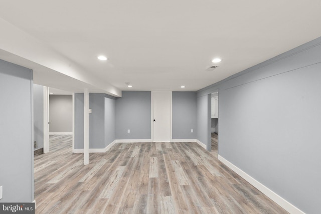 finished basement featuring recessed lighting, light wood-type flooring, and baseboards