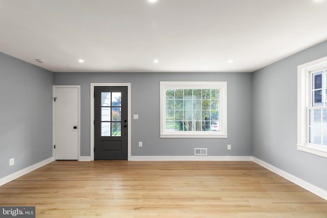 entrance foyer with a wealth of natural light, visible vents, and light wood finished floors