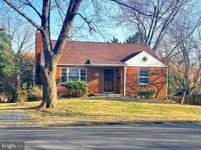 view of front of property with brick siding, a front yard, and fence