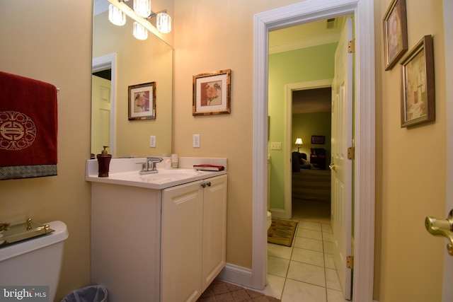 bathroom with vanity, visible vents, baseboards, tile patterned floors, and toilet