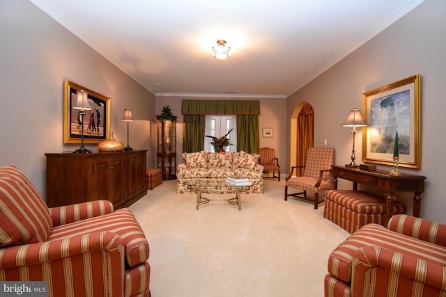 carpeted living area with arched walkways and ornamental molding