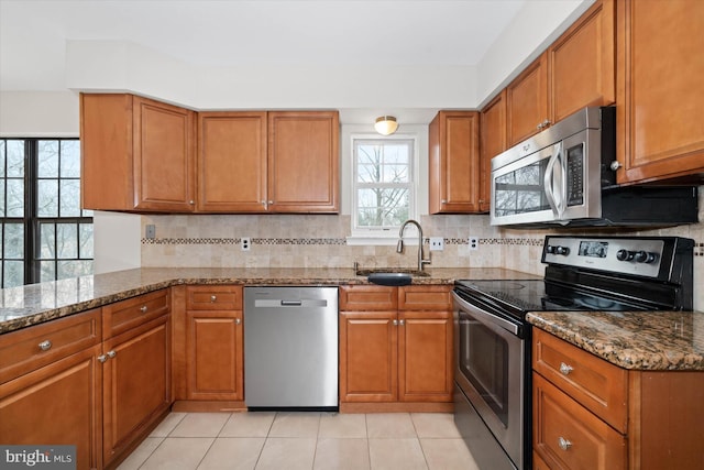 kitchen with brown cabinets, stainless steel appliances, and a sink