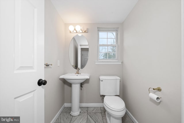 bathroom featuring toilet and baseboards