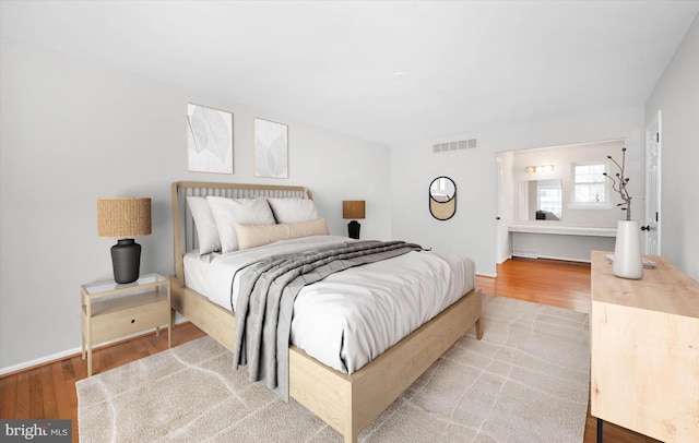 bedroom featuring visible vents, baseboards, and light wood-style flooring