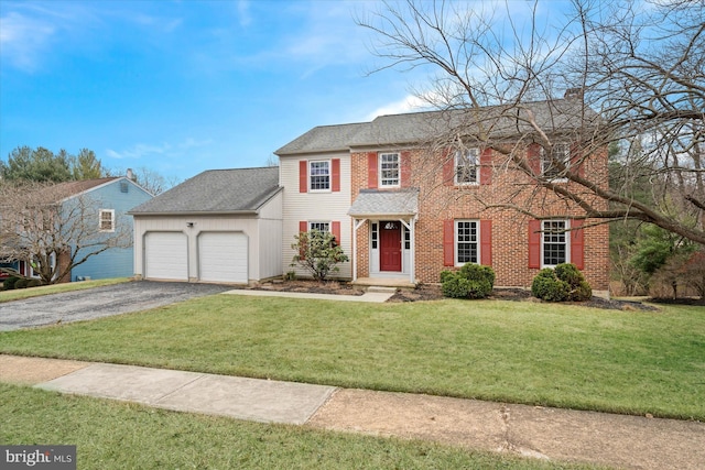 colonial-style house featuring a front yard, an attached garage, driveway, and a chimney