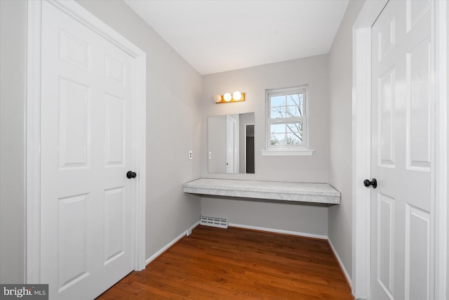 bathroom featuring visible vents, baseboards, and wood finished floors