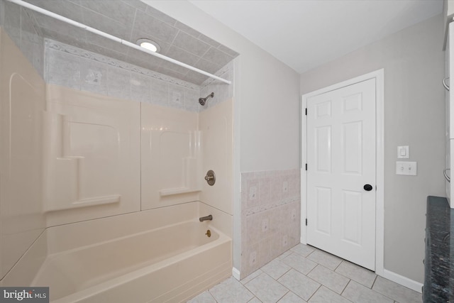 bathroom with tile patterned flooring, tile walls, and washtub / shower combination