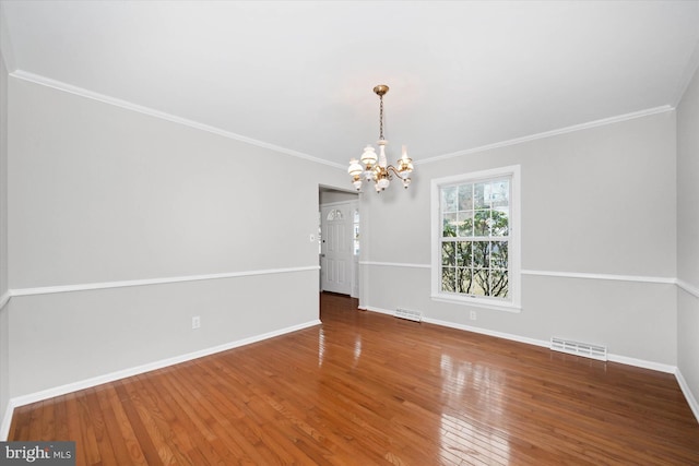 unfurnished room with a chandelier, visible vents, baseboards, and hardwood / wood-style floors