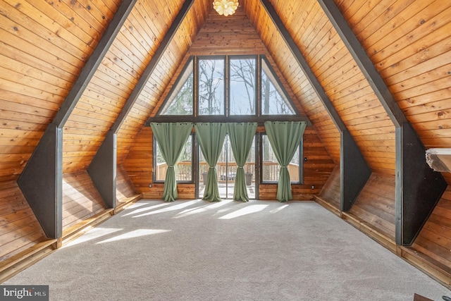 unfurnished living room featuring carpet floors, wooden walls, wood ceiling, and vaulted ceiling with beams