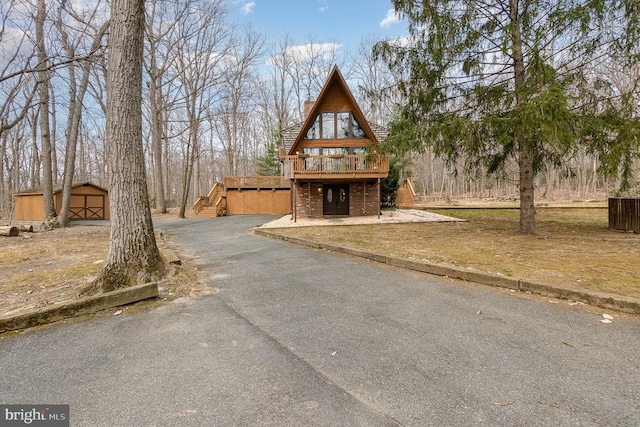 view of front of home with driveway, stairs, and an outdoor structure