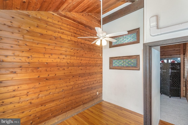 empty room featuring vaulted ceiling, light wood-style floors, wooden ceiling, and ceiling fan