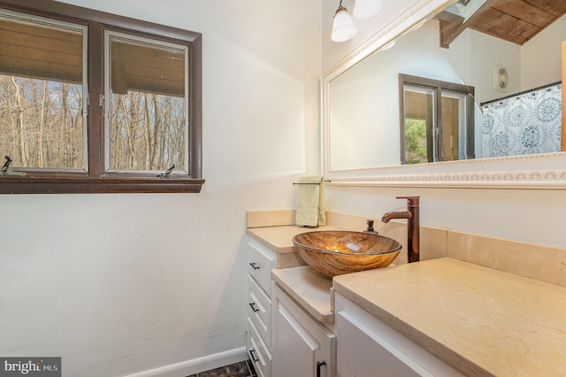 full bath featuring baseboards and vanity