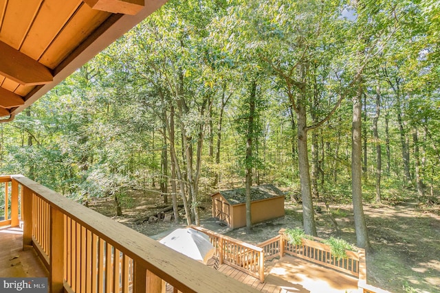 wooden terrace with an outbuilding and a wooded view