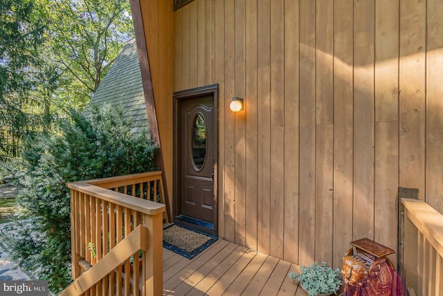 entrance to property featuring roof with shingles