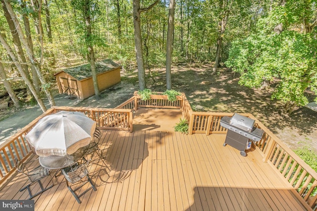 deck featuring a view of trees and a grill