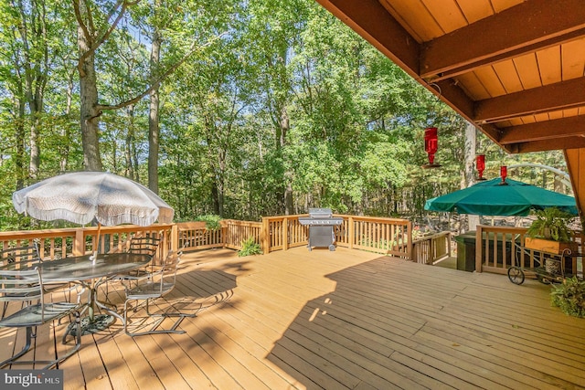 wooden deck with outdoor dining area and grilling area