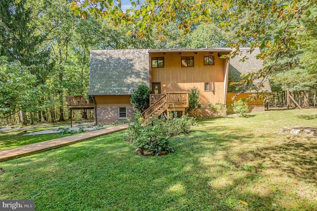 view of front of home with a deck, stairway, and a front lawn