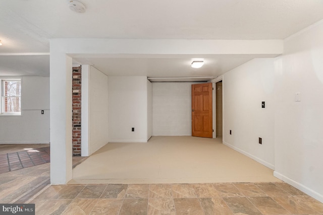 basement with stone finish flooring and baseboards