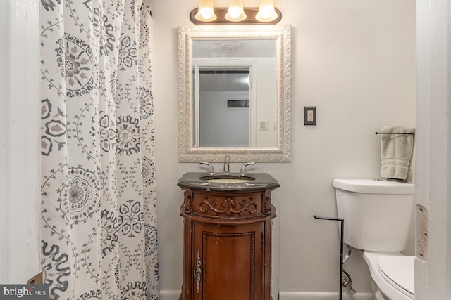 bathroom with vanity, curtained shower, and toilet