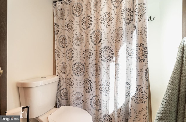 full bathroom featuring curtained shower and toilet