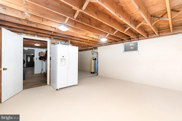 basement featuring white fridge with ice dispenser