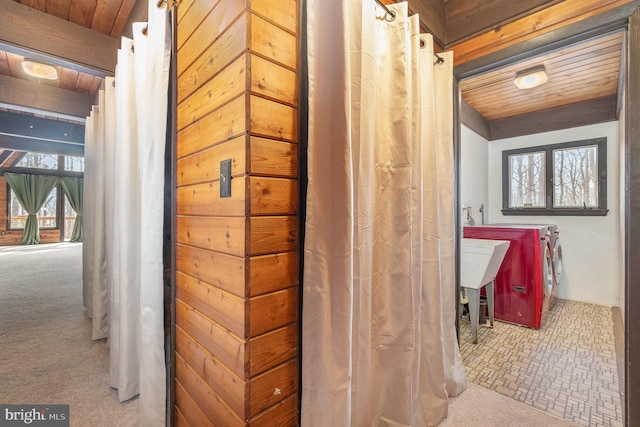 bathroom with washing machine and clothes dryer and wooden ceiling