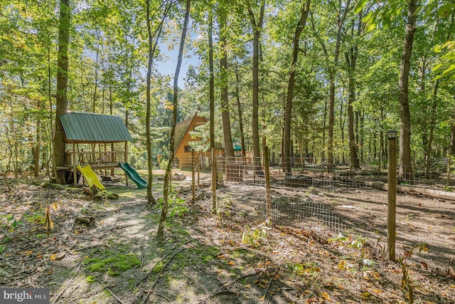 view of playground featuring a wooded view