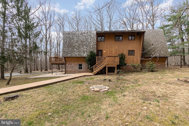 back of house with stairway, a yard, roof with shingles, and a deck