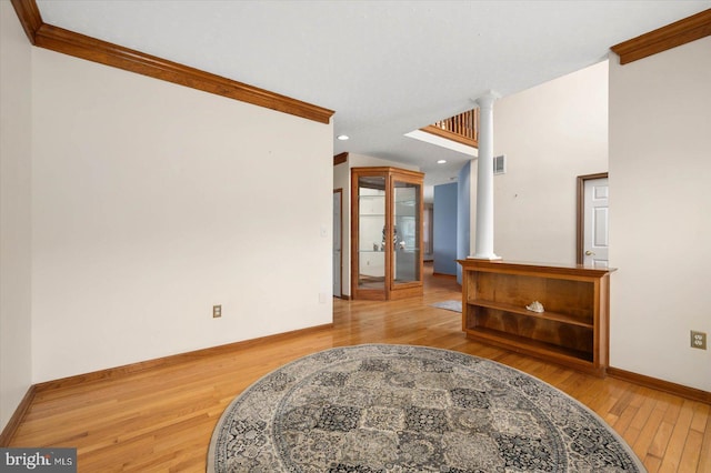 interior space with ornamental molding, recessed lighting, wood-type flooring, baseboards, and ornate columns