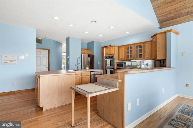 kitchen with visible vents, a sink, appliances with stainless steel finishes, light wood-style floors, and a kitchen island with sink